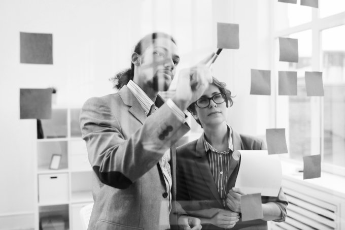 Couple working in front of the glass wall